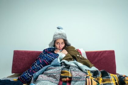 donna infreddolita con coperte e cappello