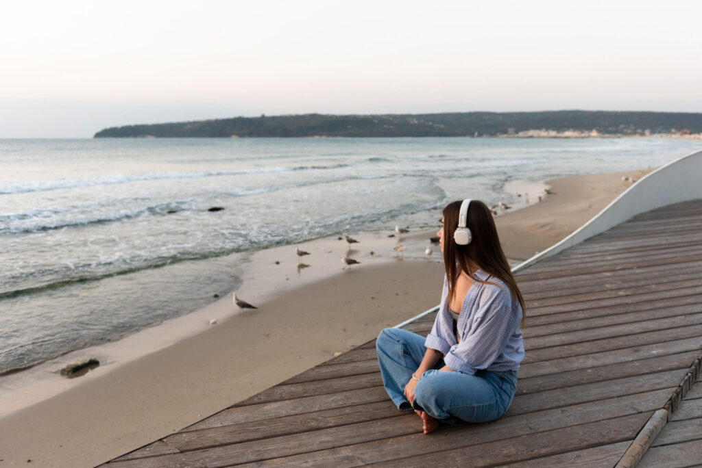 ragazza con le cuffie ascolta in riva al mare