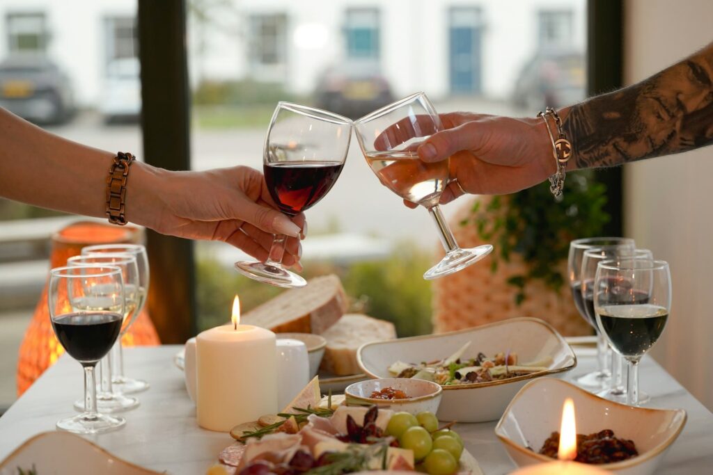due persone brindano con un calice di vino rosso e bianco