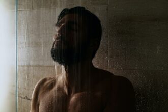 uomo fa la doccia al buio per rilassarsi